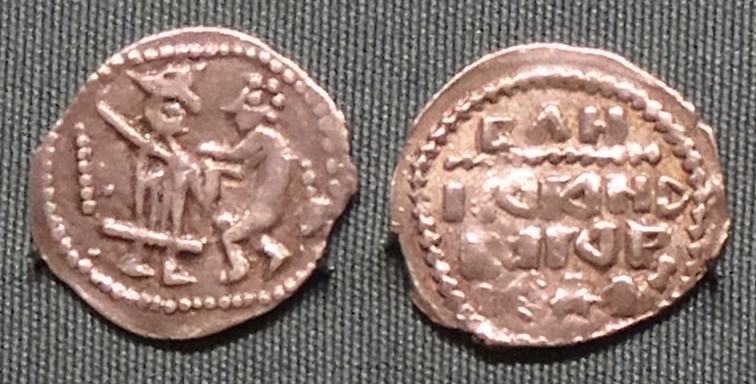 Монета Денга (князь стоит с мечом, человек справа держит предмет, точки по сторонам, строки разделены)
